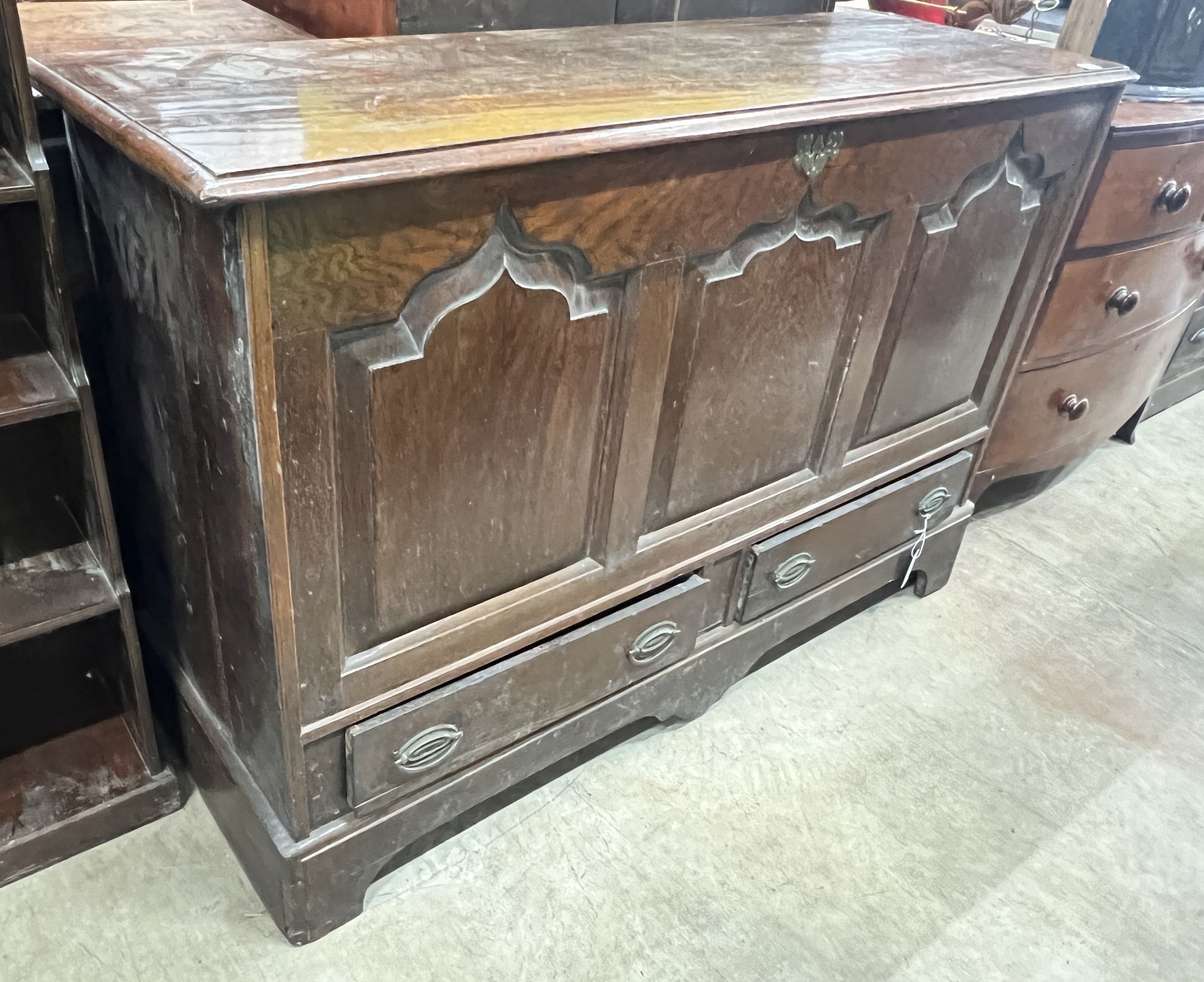 A mid 18th century oak mule chest with arched triple panelled front, width 144cm, depth 51cm, height 97cm